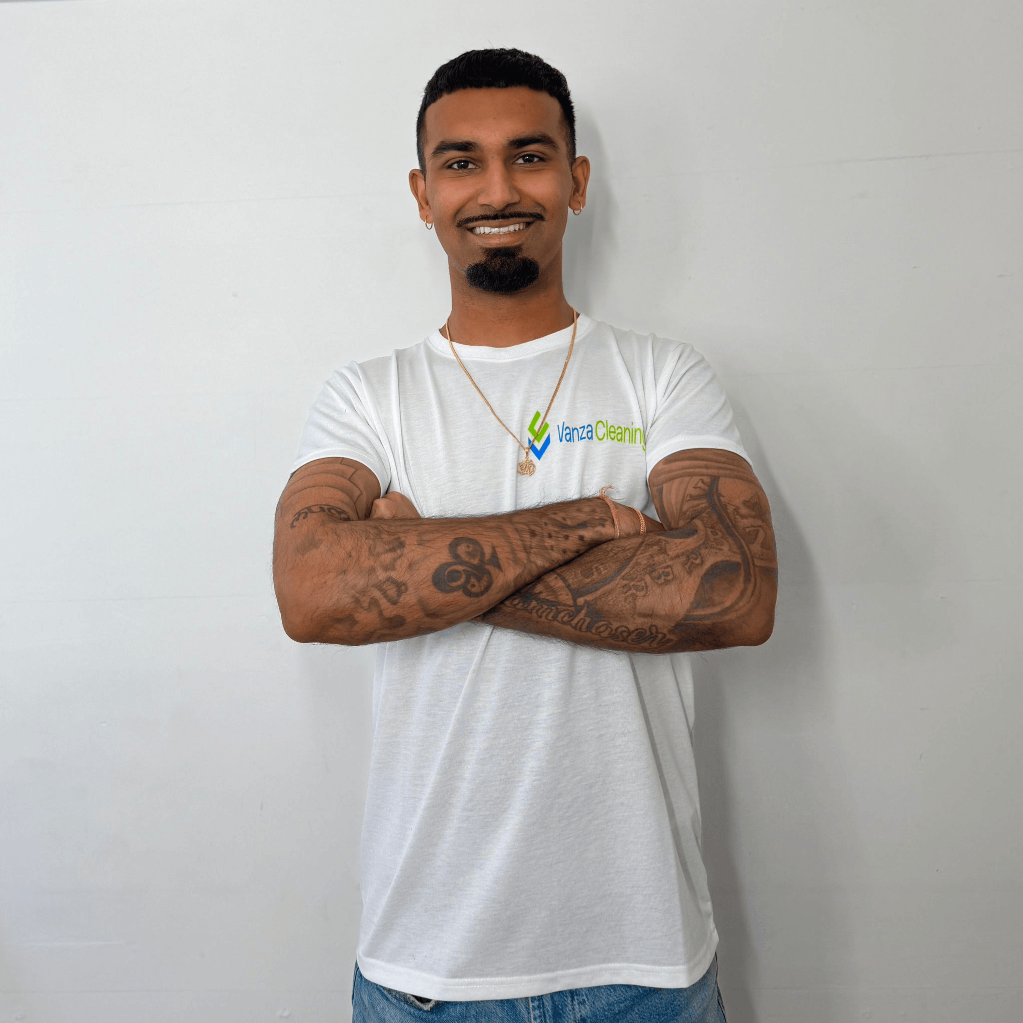 A professional, high-end cleaning team member in a branded teal uniform, smiling while organizing a modern, luxurious London apartment living room. Bright, natural lighting, premium feel.