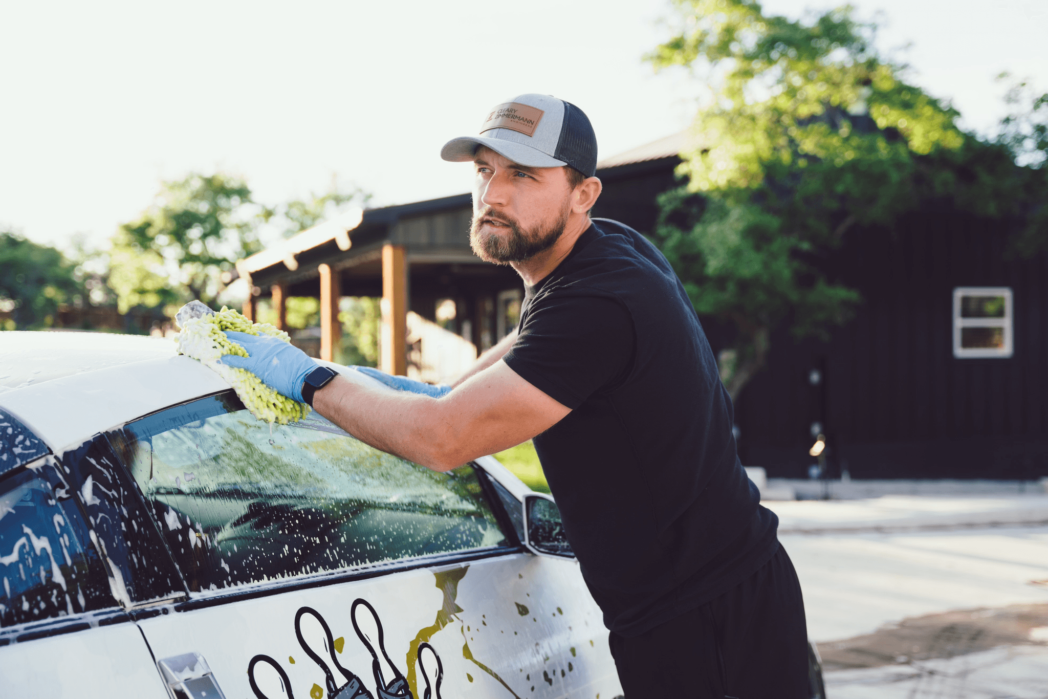 Tanner, owner of Texas Automotive Care Solutions, hand-washing a vehicle in Boerne, TX