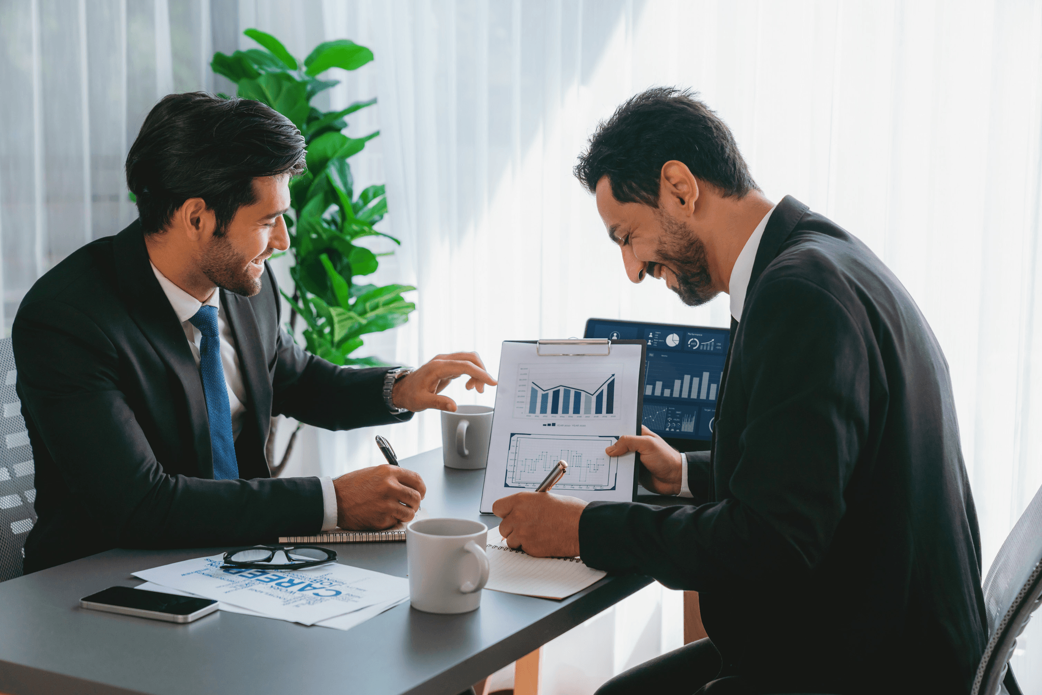 Professional business consultants reviewing revenue architecture diagrams and financial flow charts on a large screen in modern office, strategic planning session