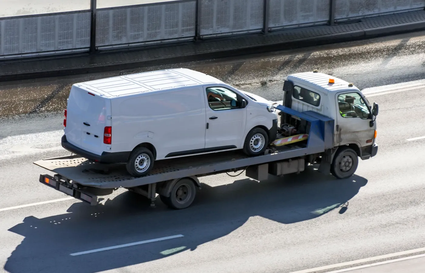 Bus niesprawny na lawecie, laweta jedzie po autostradzie