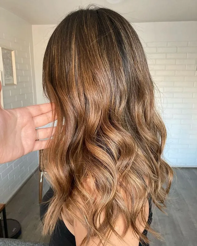 Foto de una mujer con cabello largo y ondulado, de color castaño claro