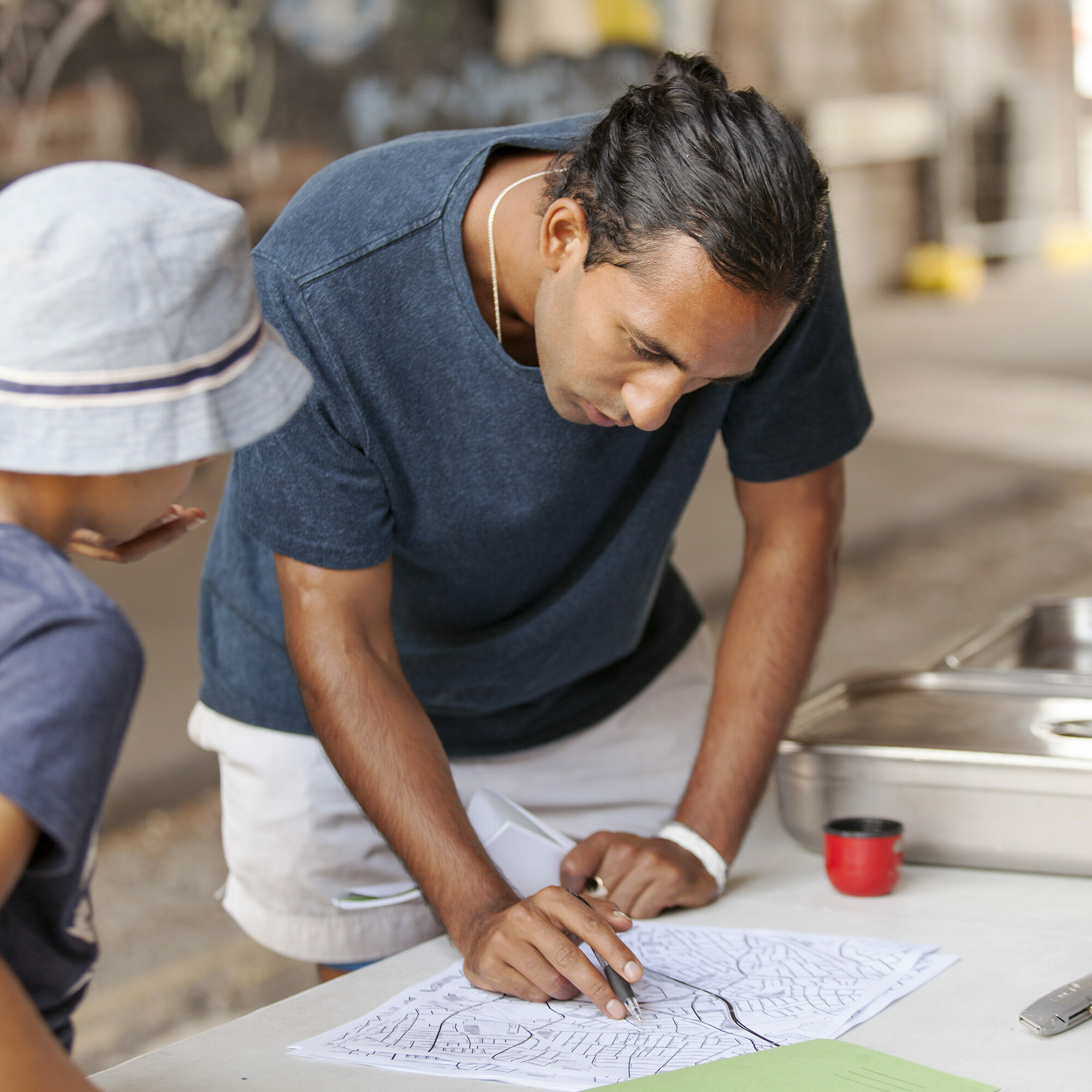 A man leaning over a table looking over a map with a child