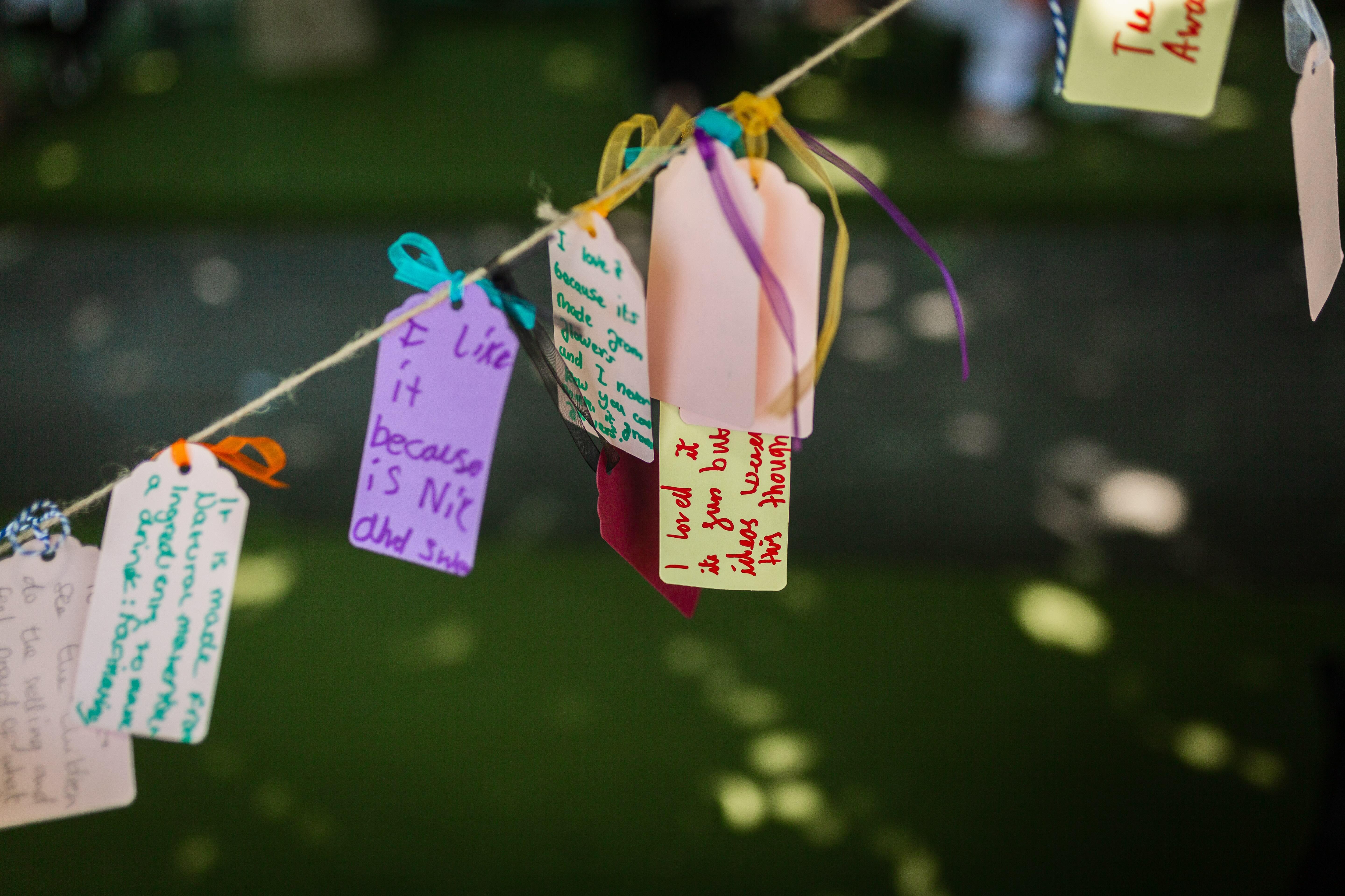 A number of small cards covered in writing hanging on a string