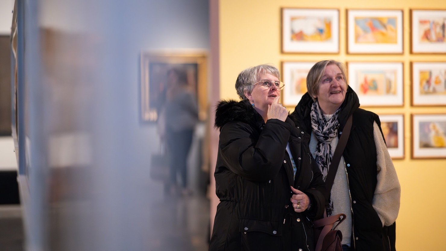 Two women looking at an exhibition