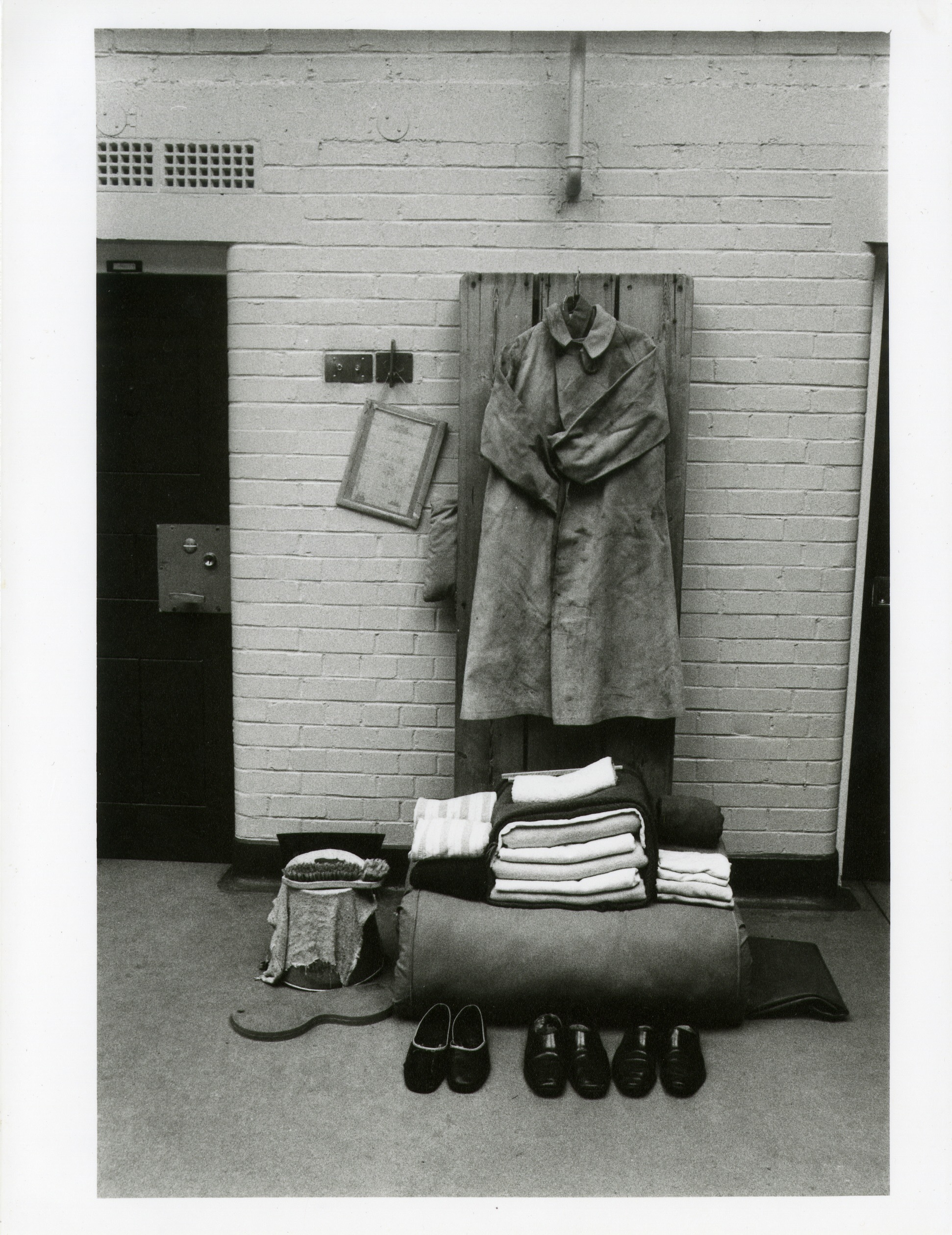 Black and white photograph of prison objects beside a door