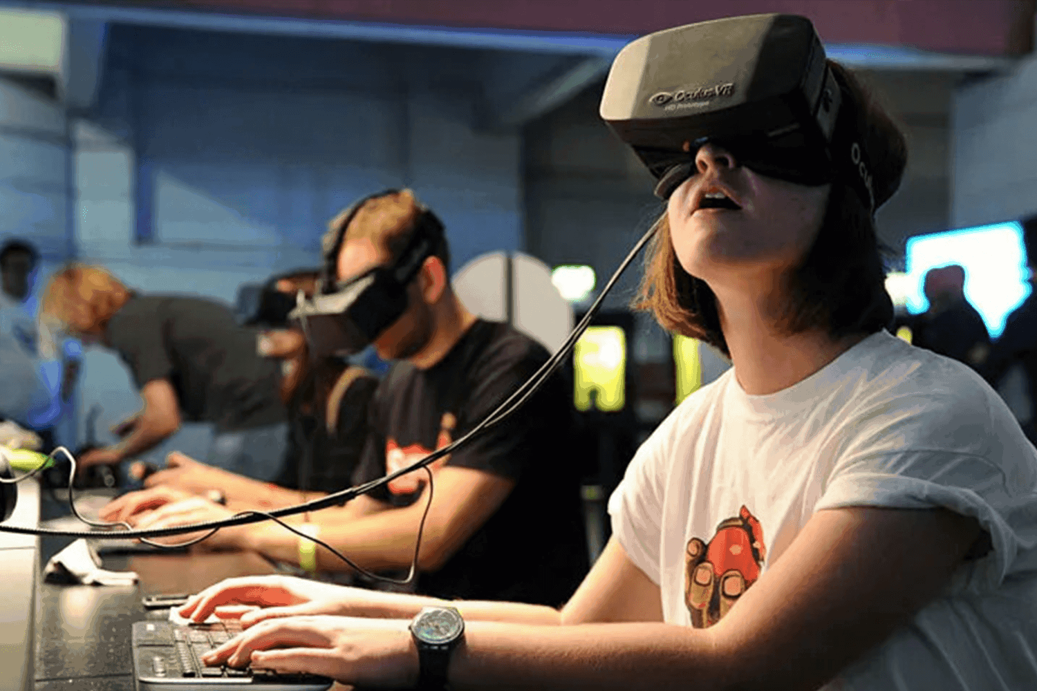 A person sits at a desk with a VR headset on