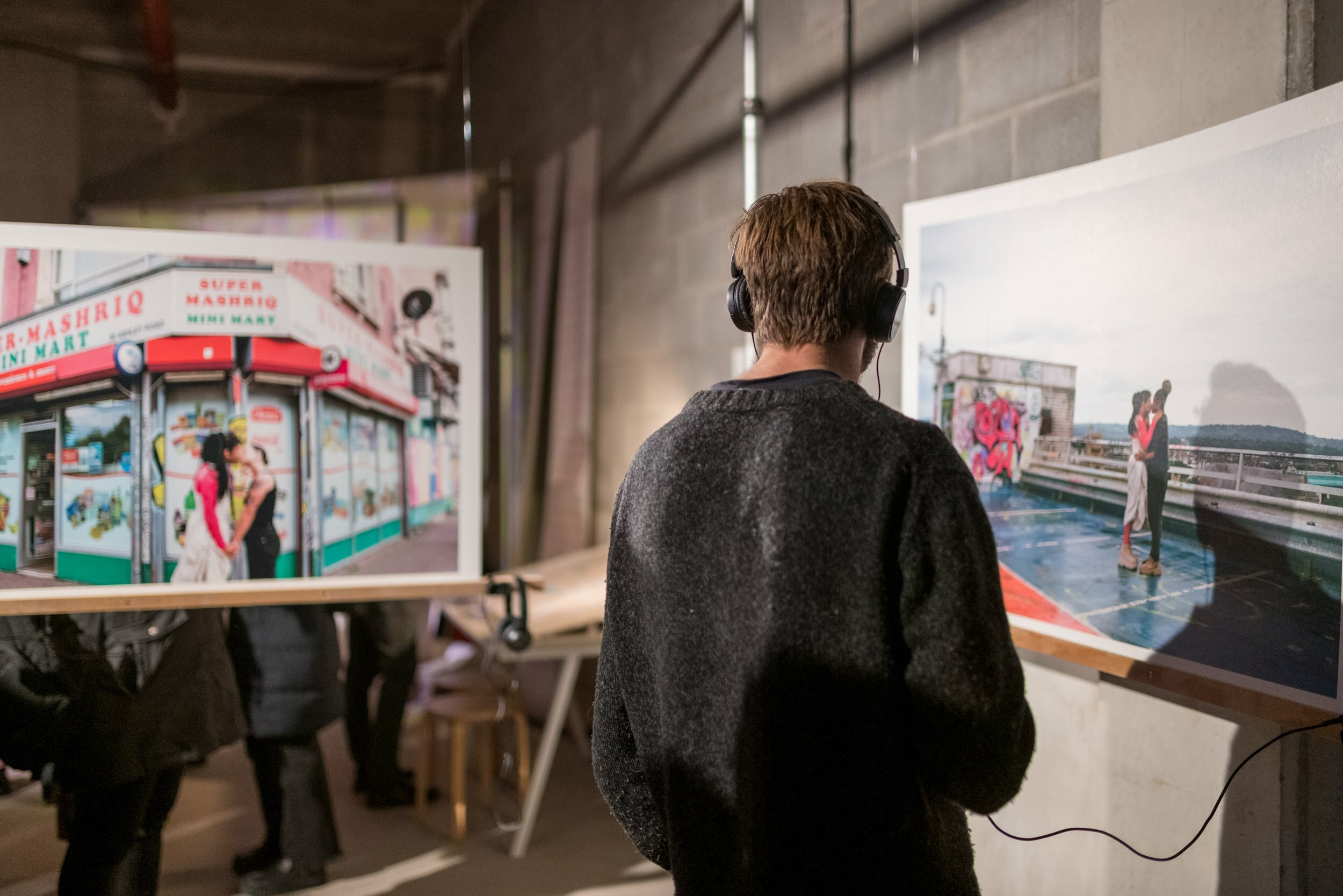 a person wearing headphones is looking at some hanging photographs