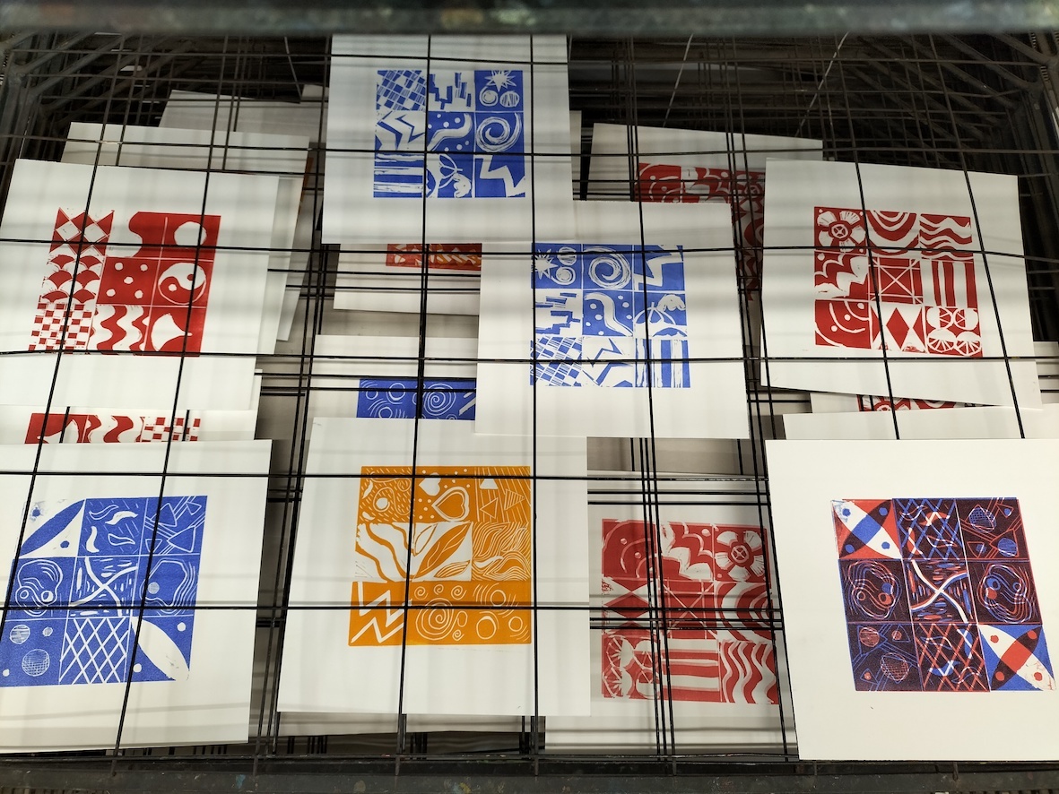 An image of linocut prints drying on a rack