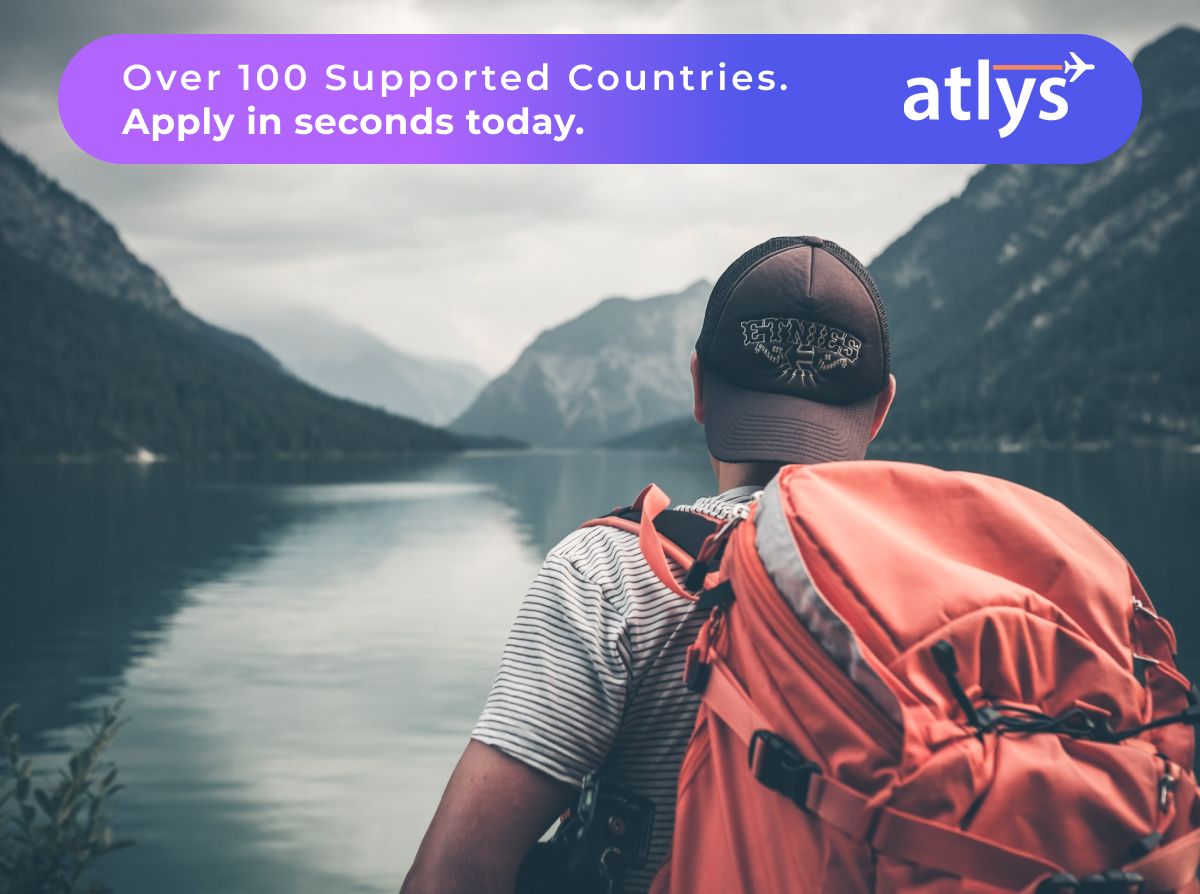 sample of visa application letter to embassy A man with a red hiking backpack facing a body of water and mountains