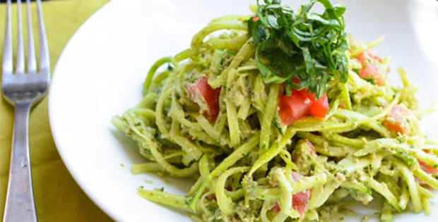 raw zucchini noodles with pesto in a bowl