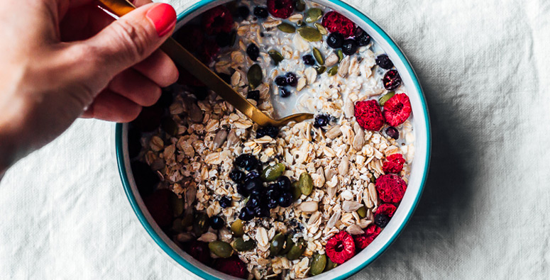 Complete homemade Muesli in a bowl with fresh fruit and almond milk