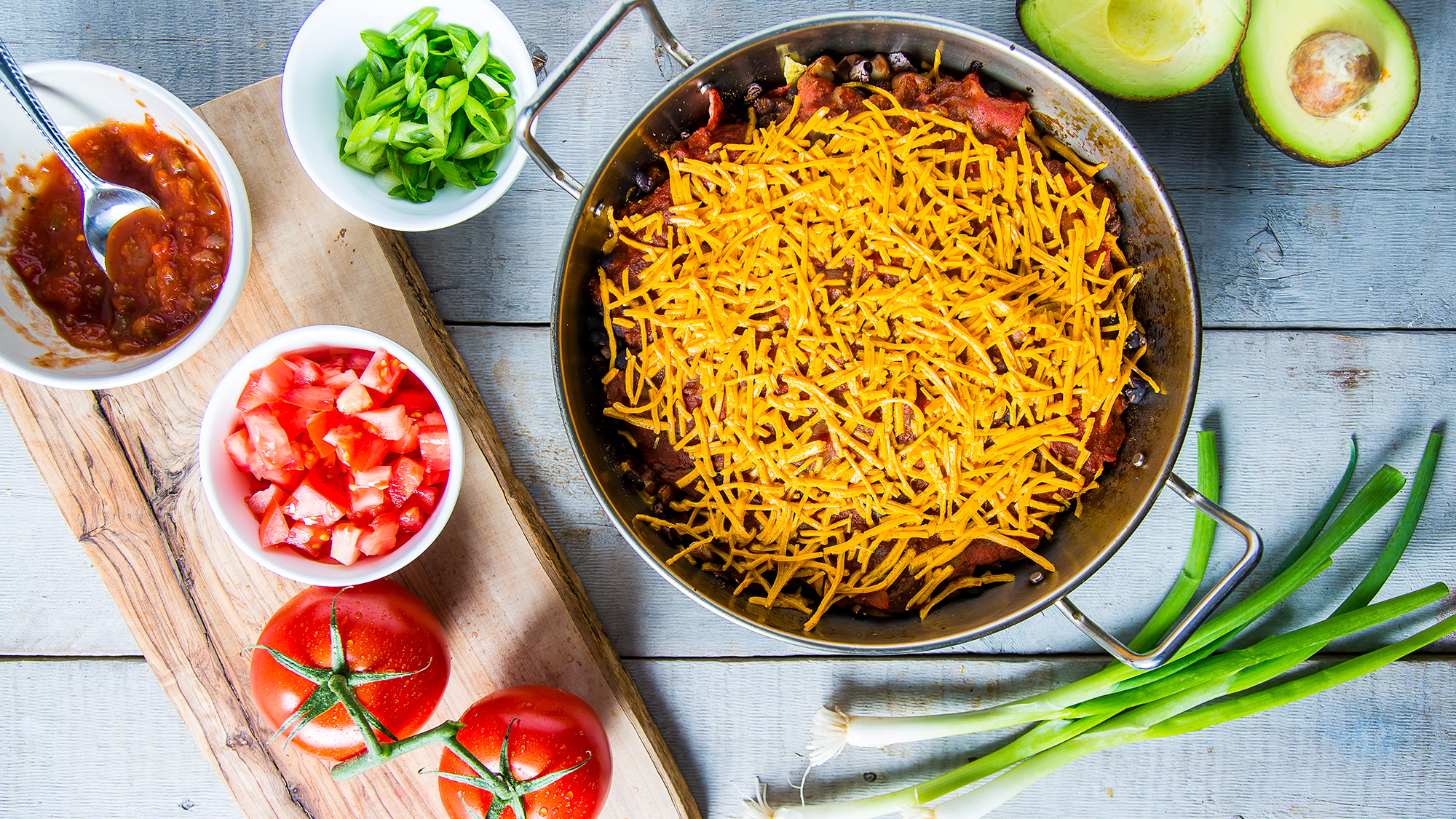 vegan chilaquiles casserole in a pot with ingredients around it