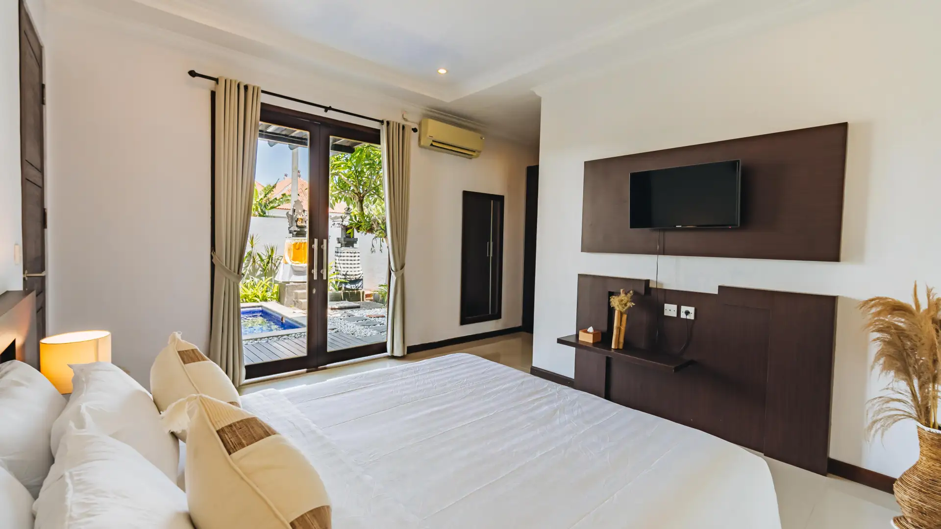 King-size bed with air conditioning and large windows - Villa Griya Purnama