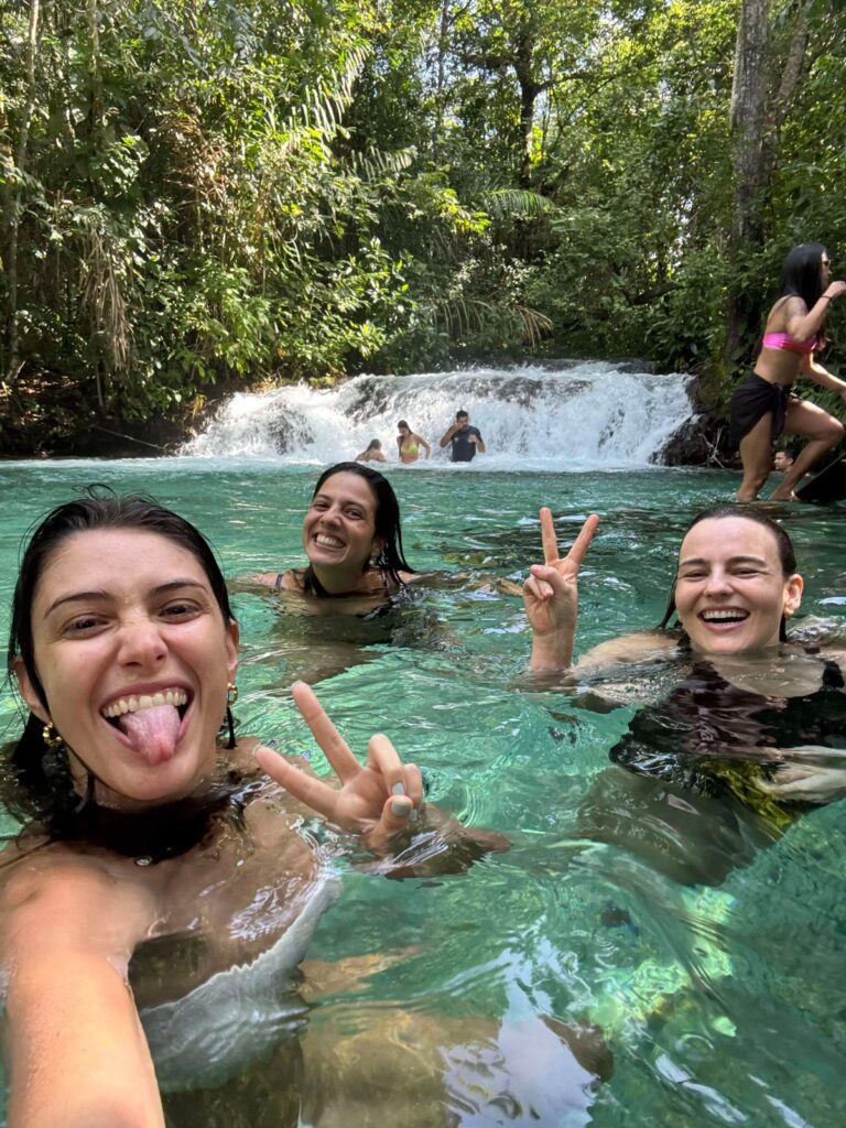 Viajantes tomando banho em cachoeira de águas transparentes no Jalapão