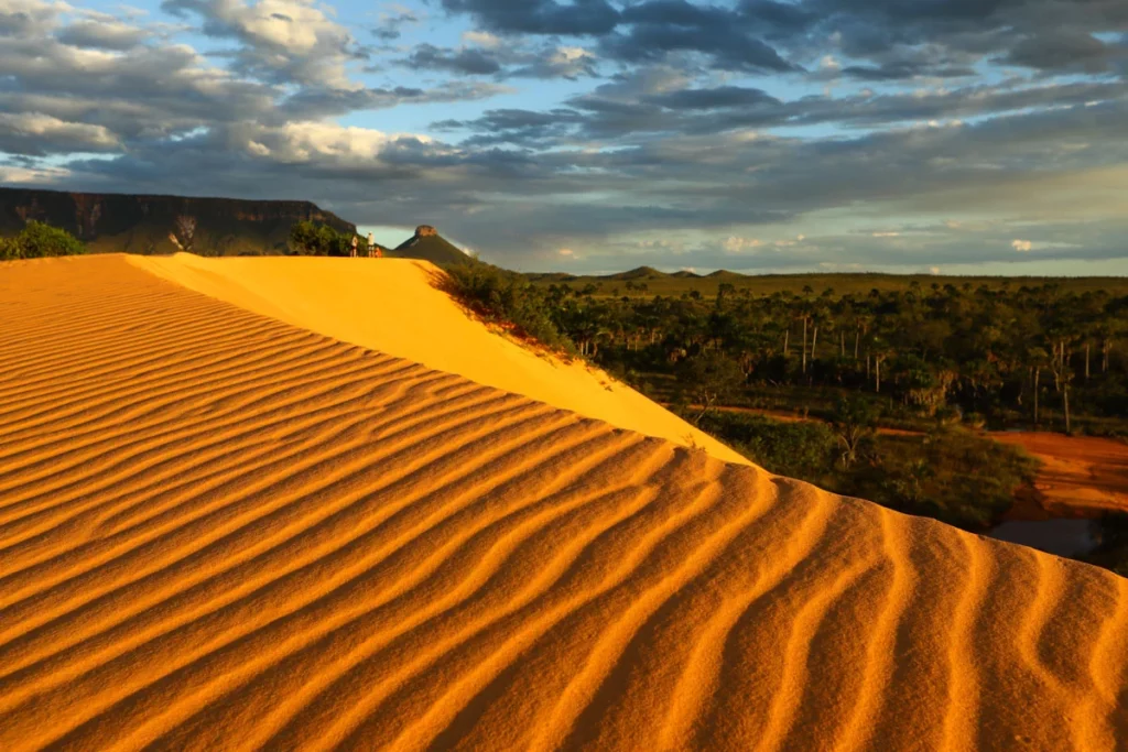 Dunas de areia dourada com serras ao fundo no Jalapão