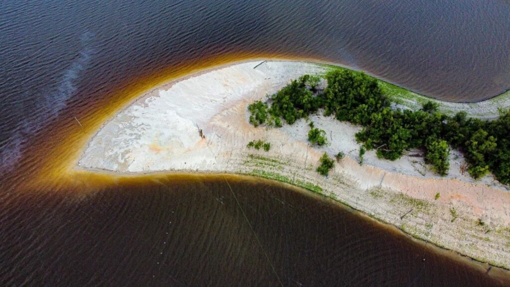  Águas escuras do Rio Negro ao lado de praia de areia no Amazonas