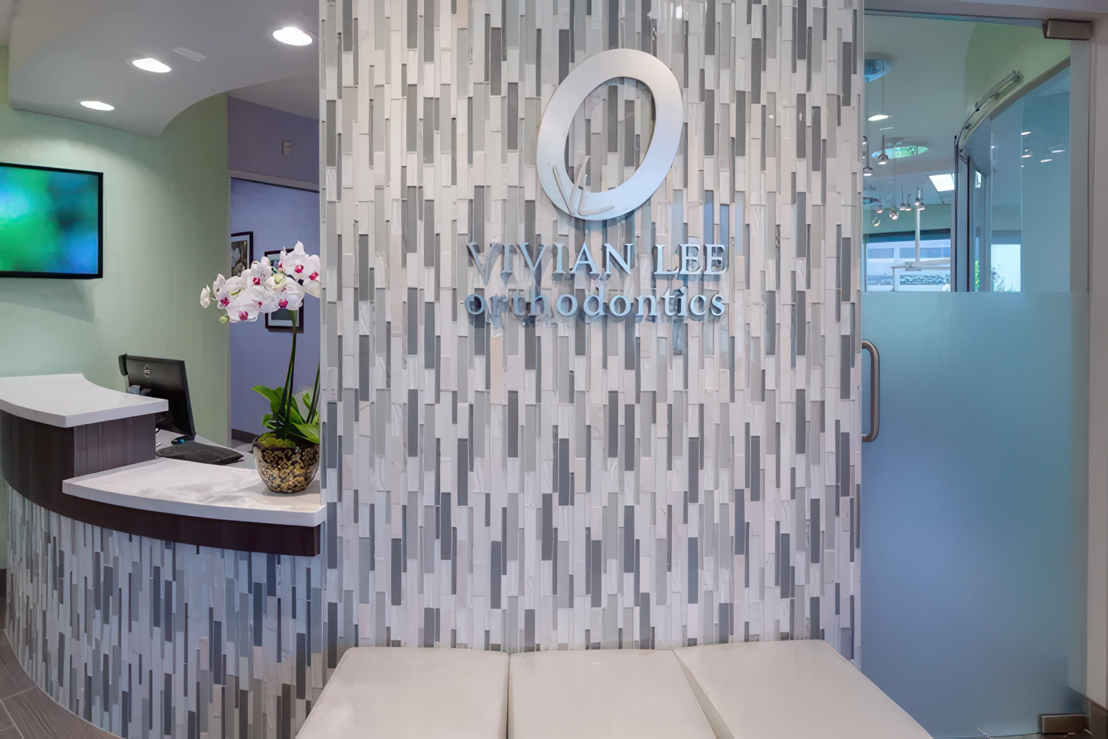 Full reception area with branded wall, front desk, and designer lighting