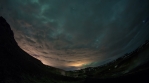 Geothermal mountain valley fumeroles glowing Aurora behind clouds Krysuvik Iceland