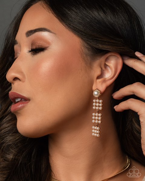 profile closeup of a woman pulling her dark hair back to reveal a cascading pearl paparazzi accessor…
