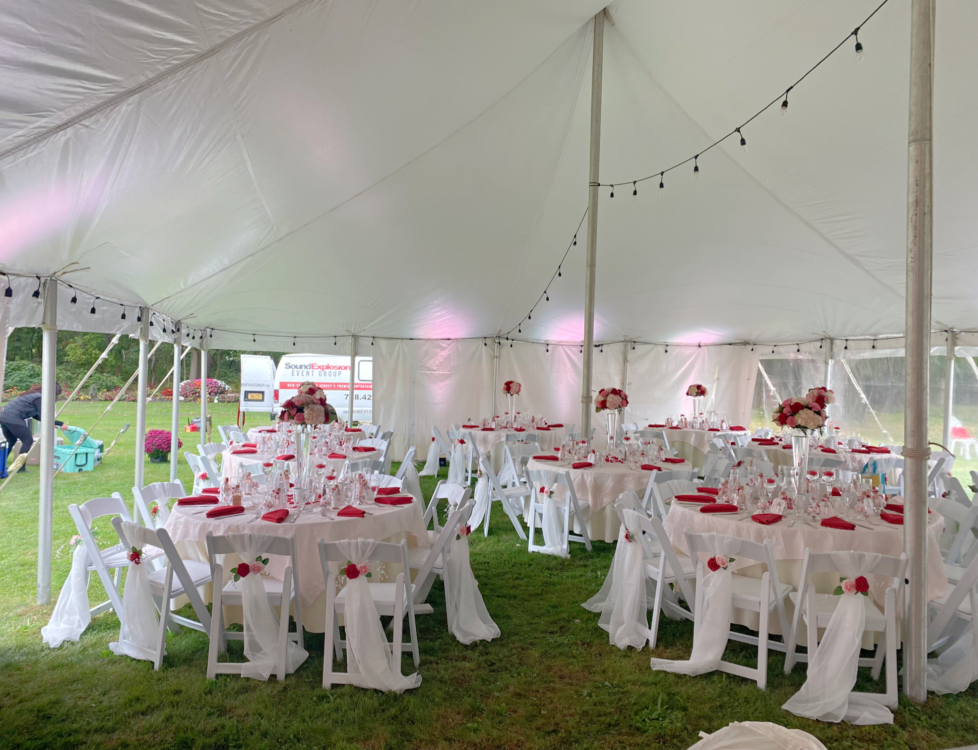 Party tent interior with formal round tables and draped chairs