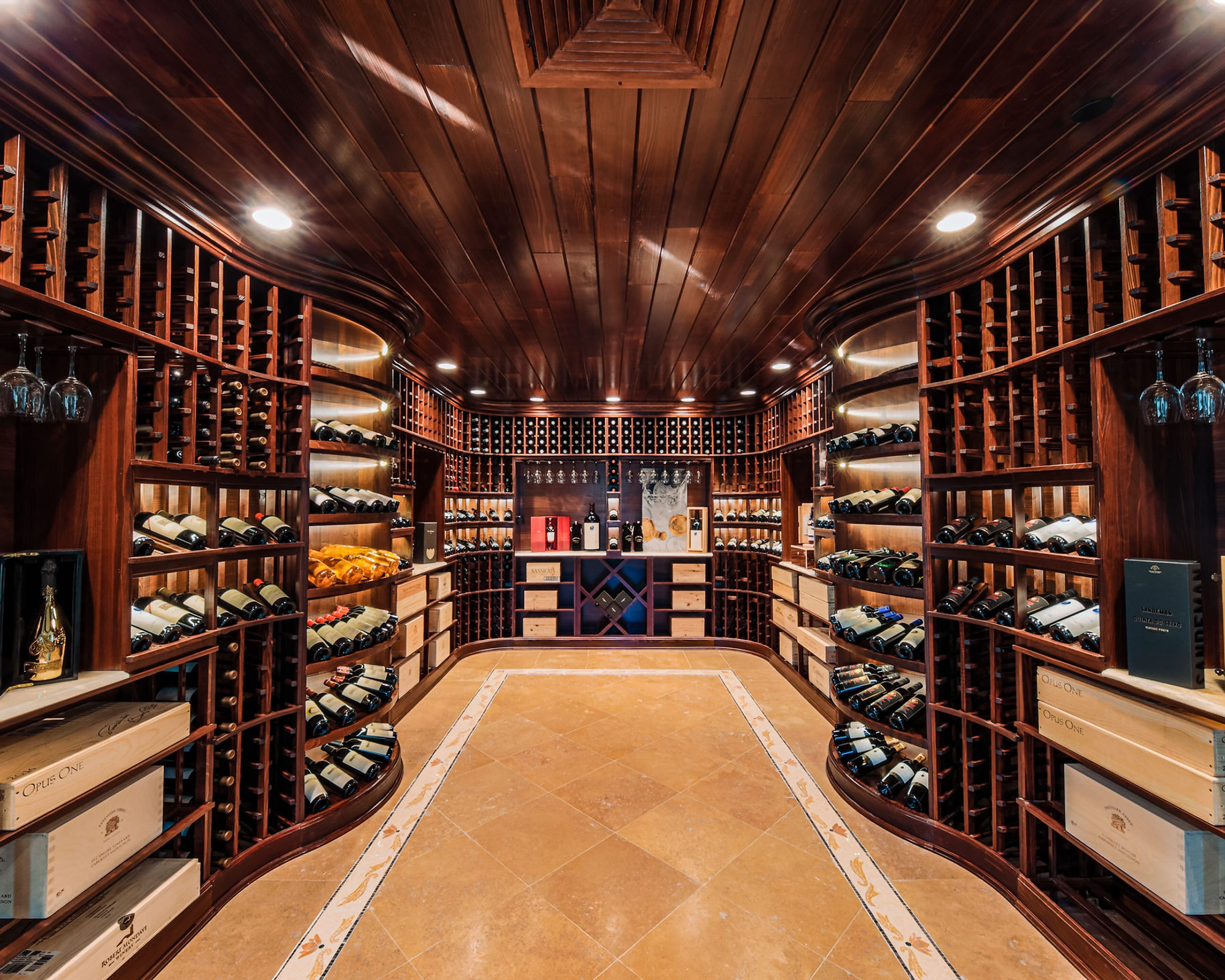 Wooden wine cellar at Shadowbrook lined with bottles and arched shelving