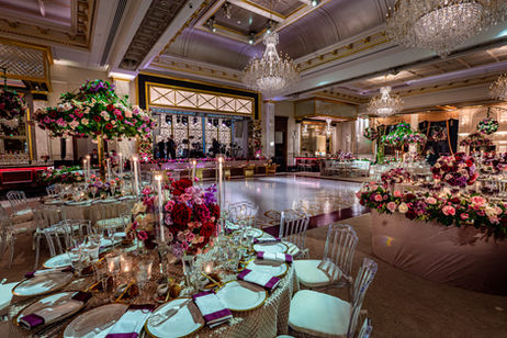 Grand ballroom at Shadowbrook decorated with pink floral centerpieces, chandeliers and formal table settings