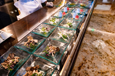 Close-up of plated gourmet appetizers arranged on a glass service counter