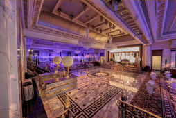 Empty venue space with patterned tile floors, high ceilings and ambient purple lighting