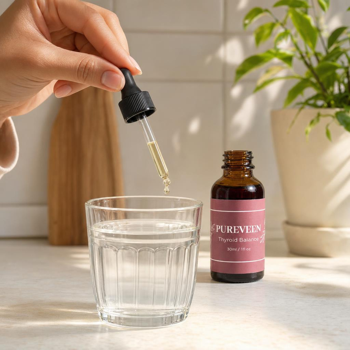 A dropper of Pureveen held above a glass of water