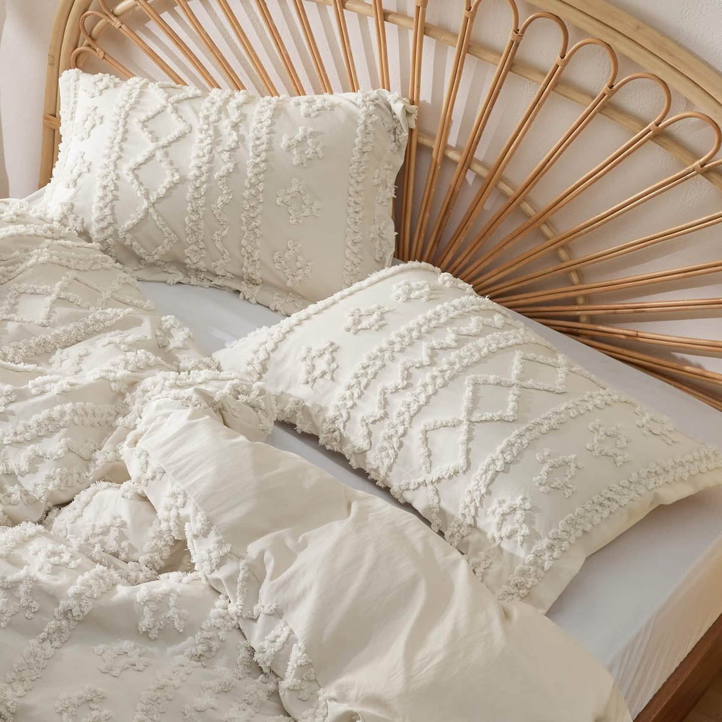 The comforter and matching tufted shams styled against the headboard