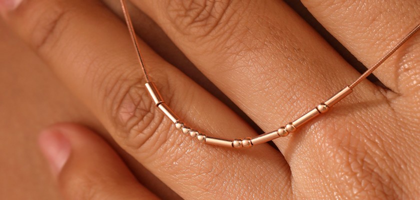 Tulas Morse Code Necklace shown in hand