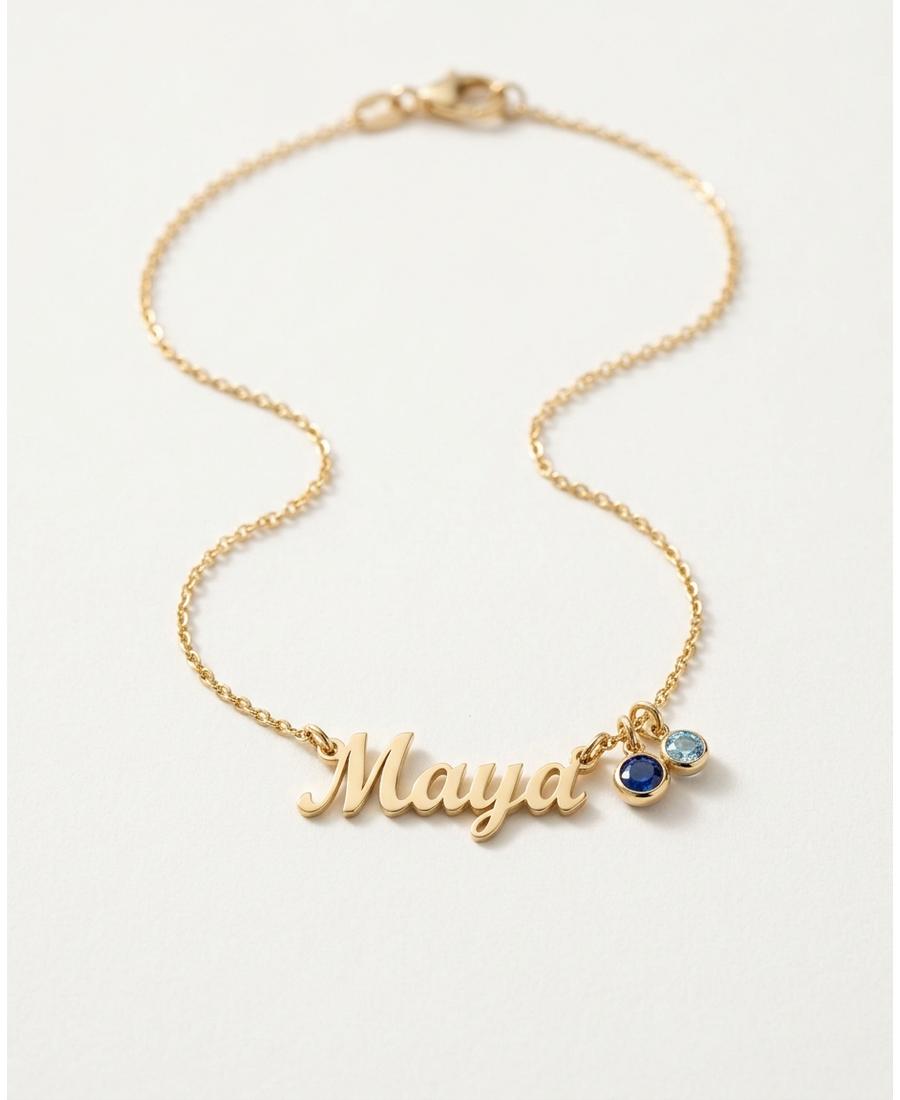 A gold personalized name necklace with birthstone charms