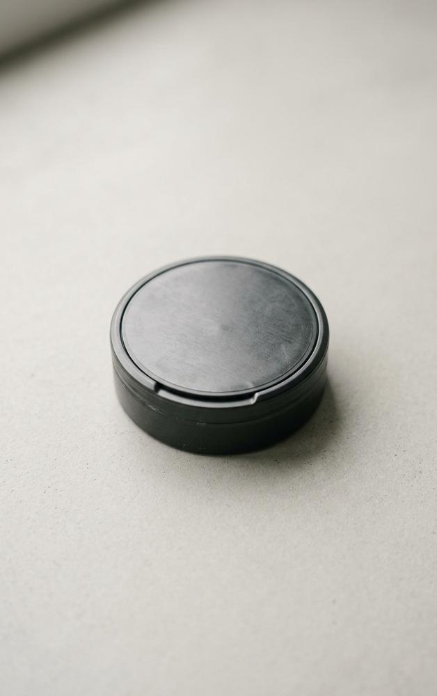 A plain nicotine pouch tin