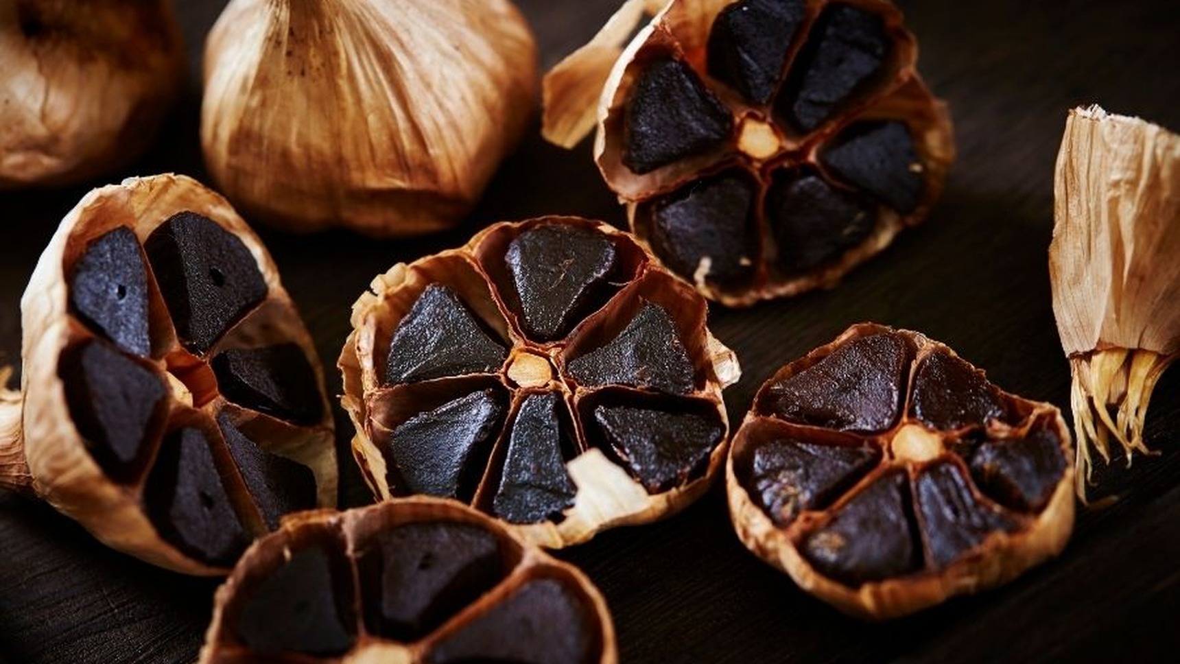 Halved bulbs of slow fermented black garlic