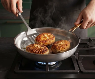 Browning food in the Taima pan on a gas hob