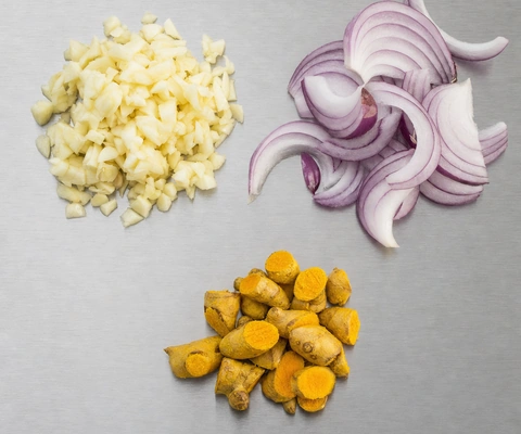 Garlic, onion and turmeric prepped on a titanium board