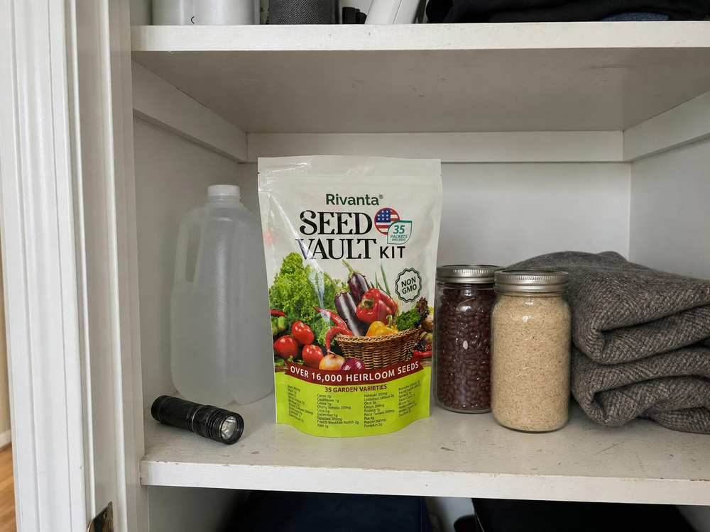 The sealed seed vault pouch on a pantry shelf beside canned goods, bottled water and a folded blanket.