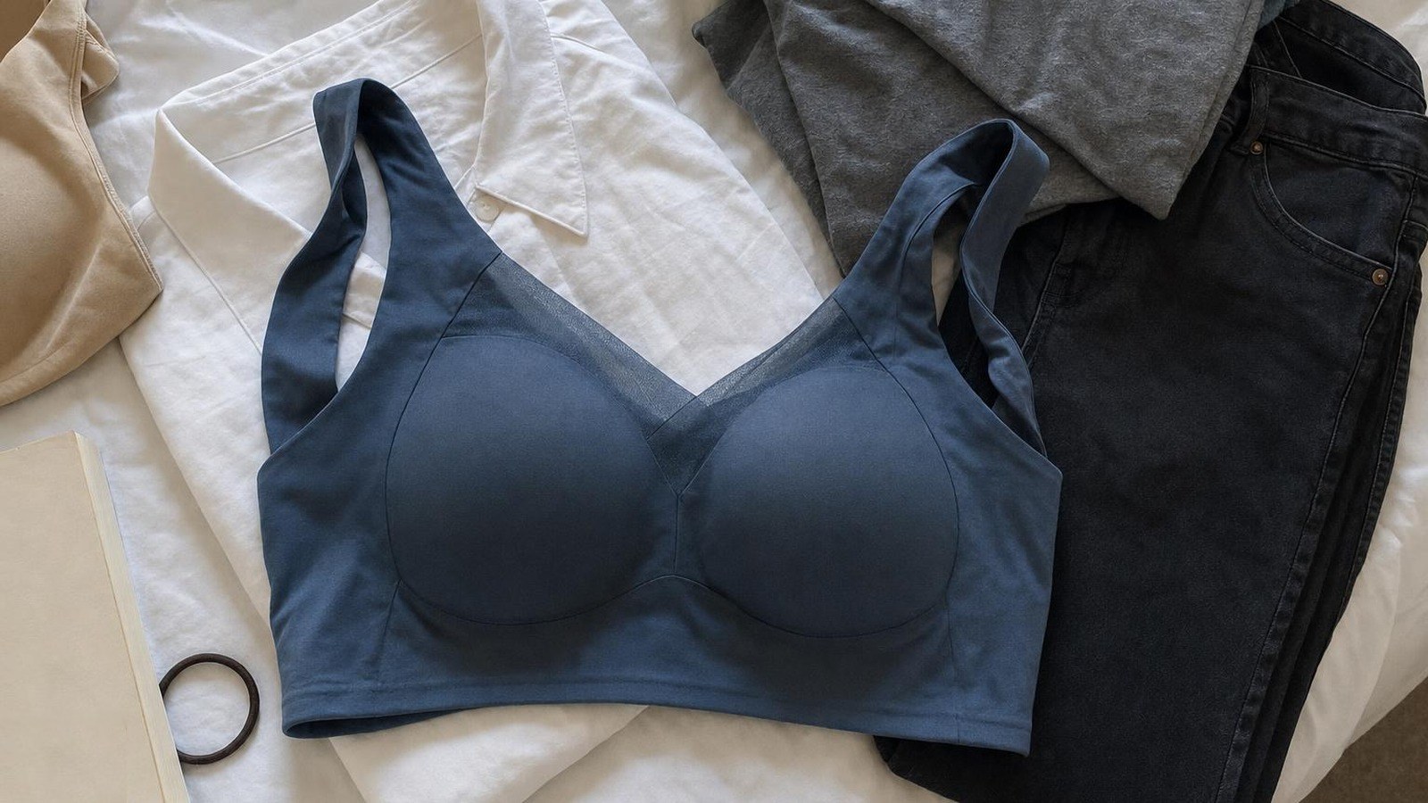 Il reggiseno push-up senza cuciture Vitelli Moda in blu scuro sul letto, accanto ai vestiti preparati per il giorno dopo