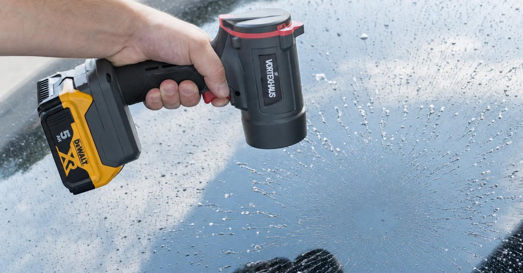 VortexHaus MACH held one-handed, blasting water off a wet windshield