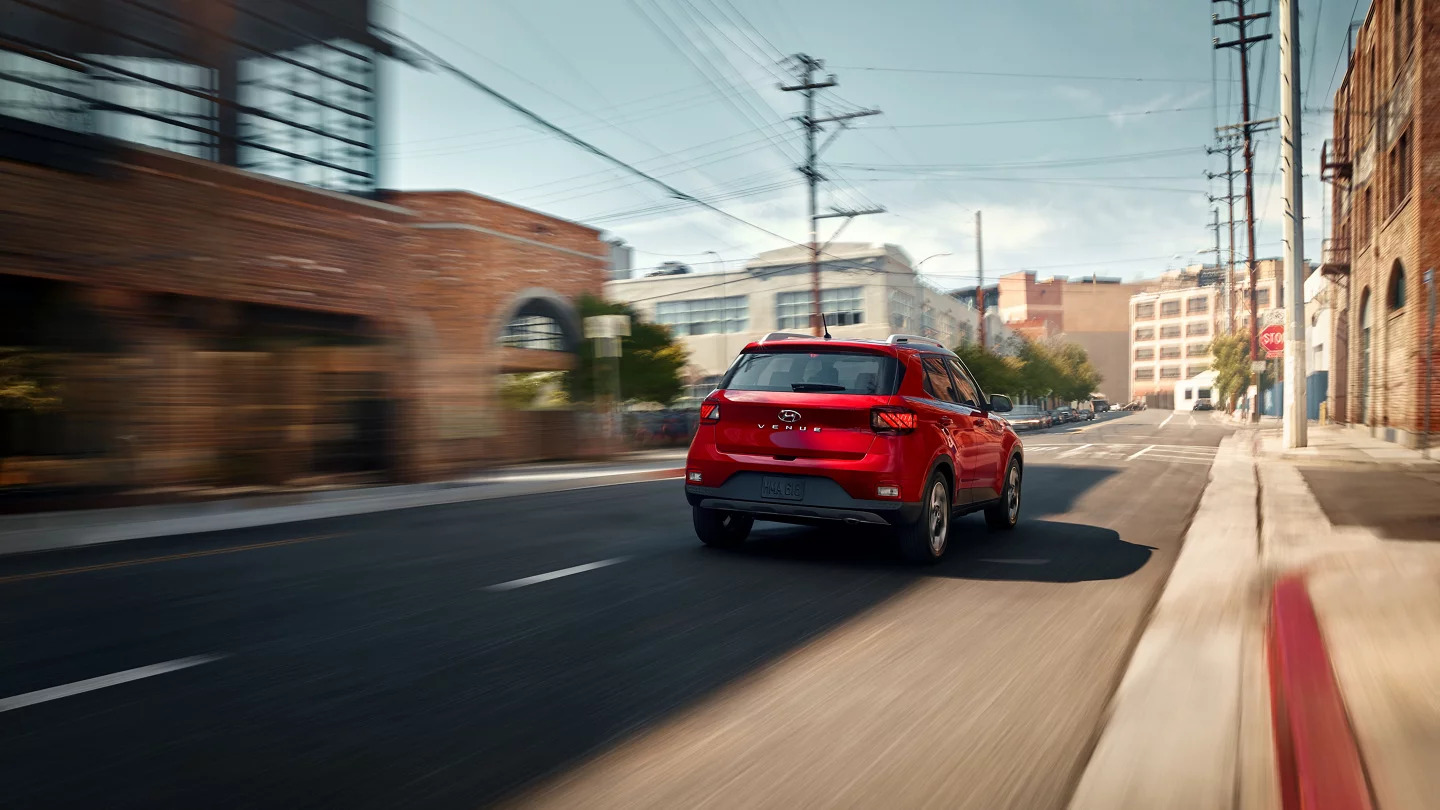 A red car driving down the road.