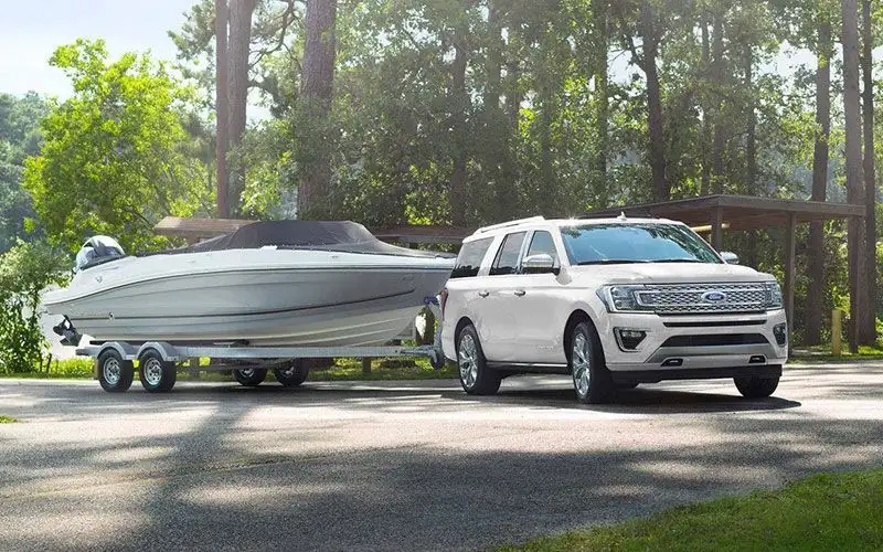 image of white ford expedition towing boat