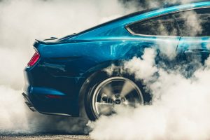 close up of the rear of a blue 2018 Ford Mustang GT in the middle of a burnout