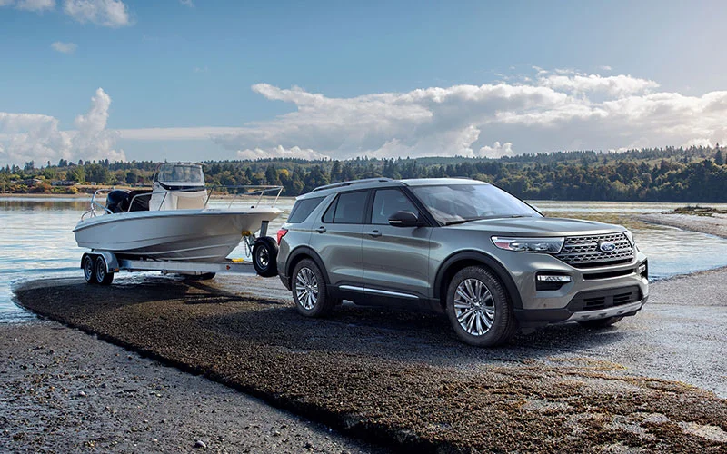 image of silver ford explorer towing boat by lake