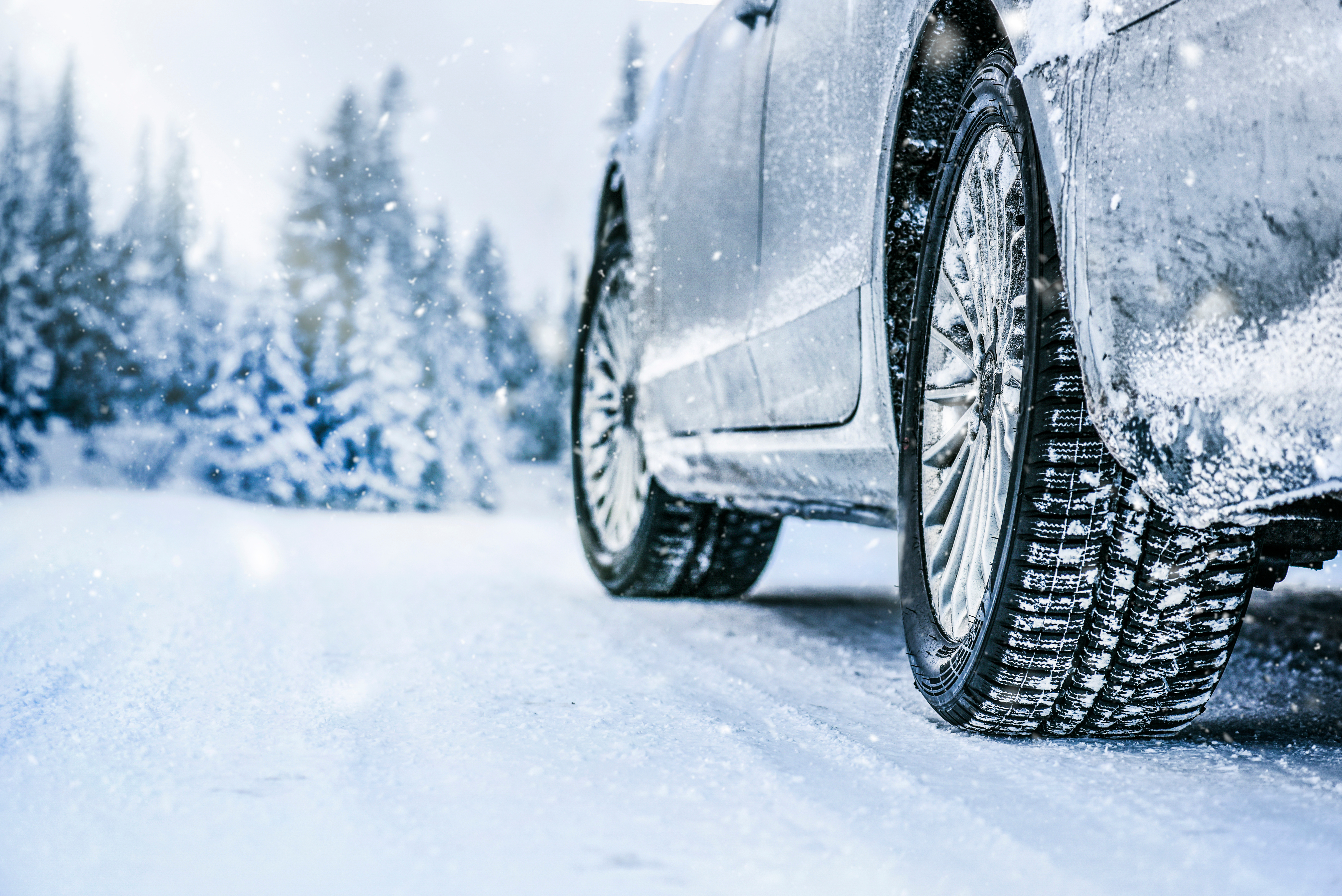 winter tires on a silver car with a snowy landscape