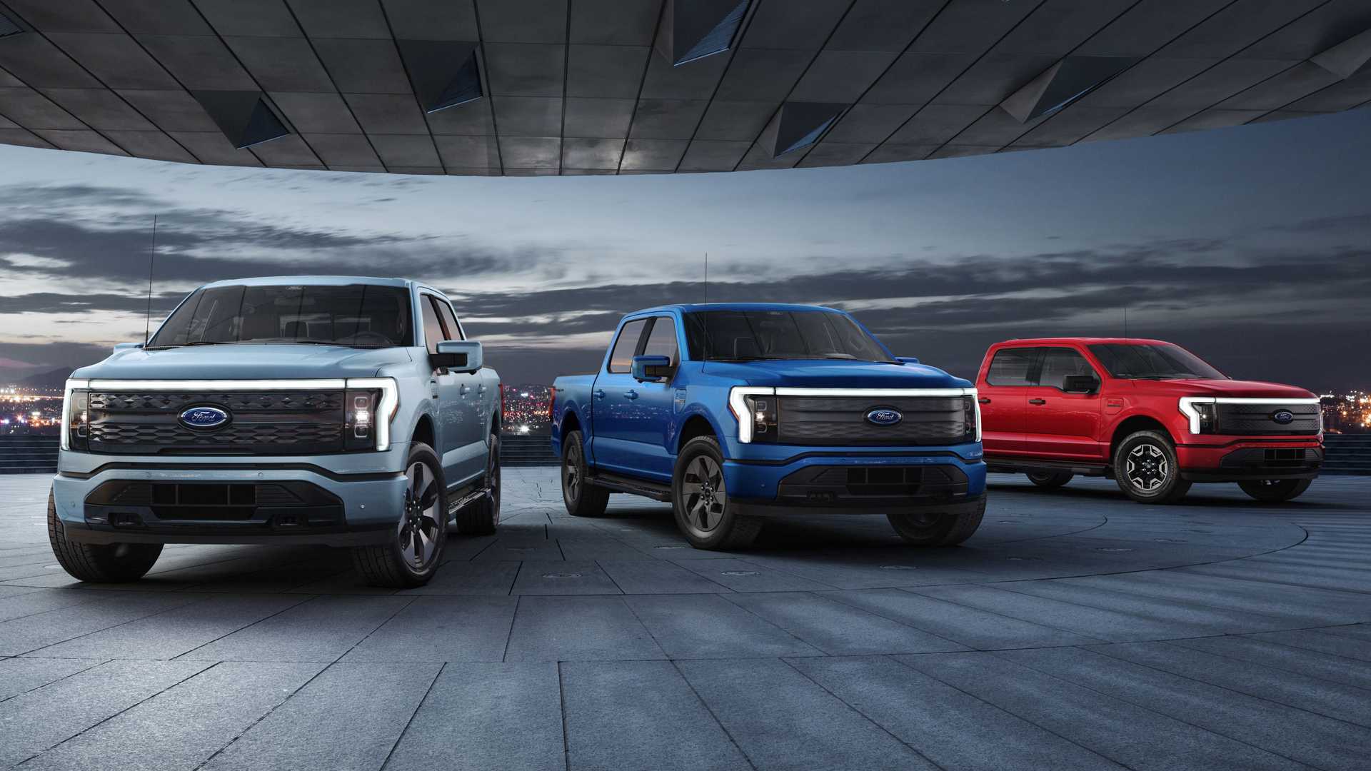 Three 2022 F-150 Lightning in red, blue and grey on a road