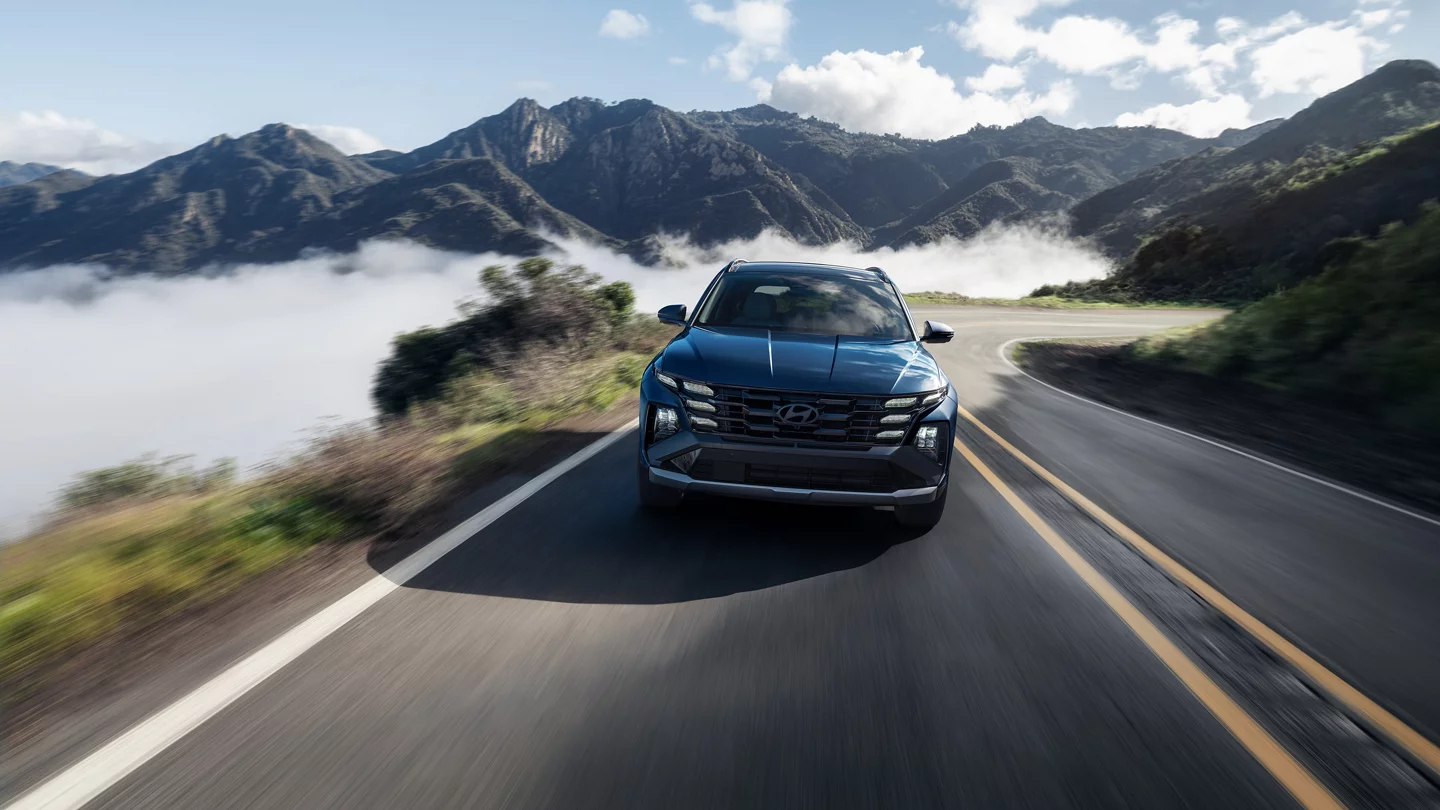 A Hyundai Tucson driving on a road.