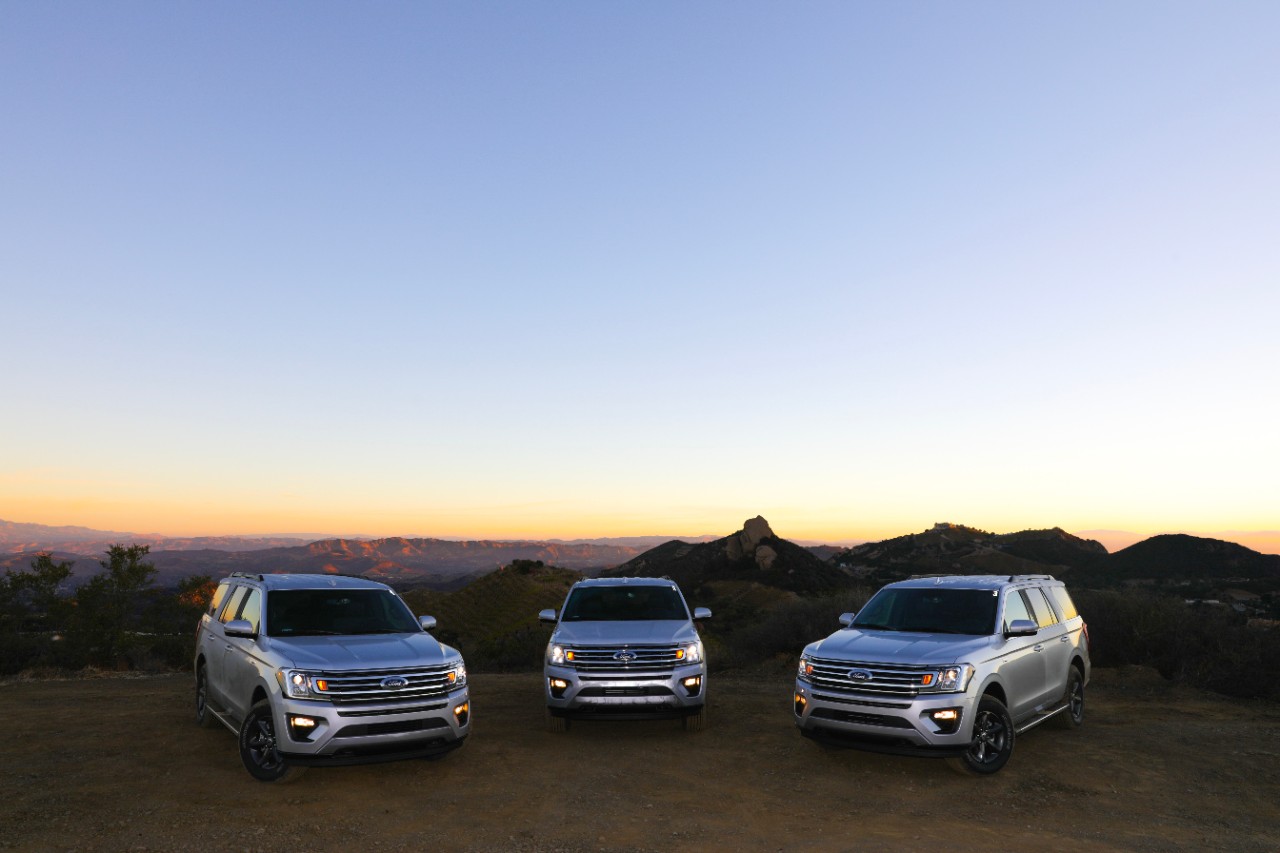 SUVs on a mountain against a sunset