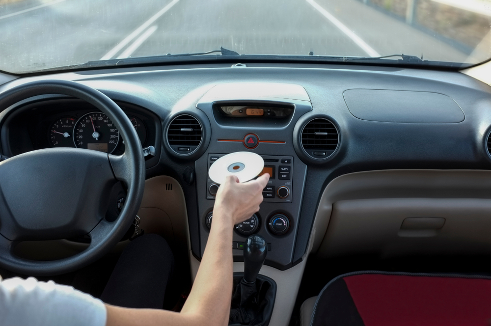 driver inserts CD into their vehicle's CD player