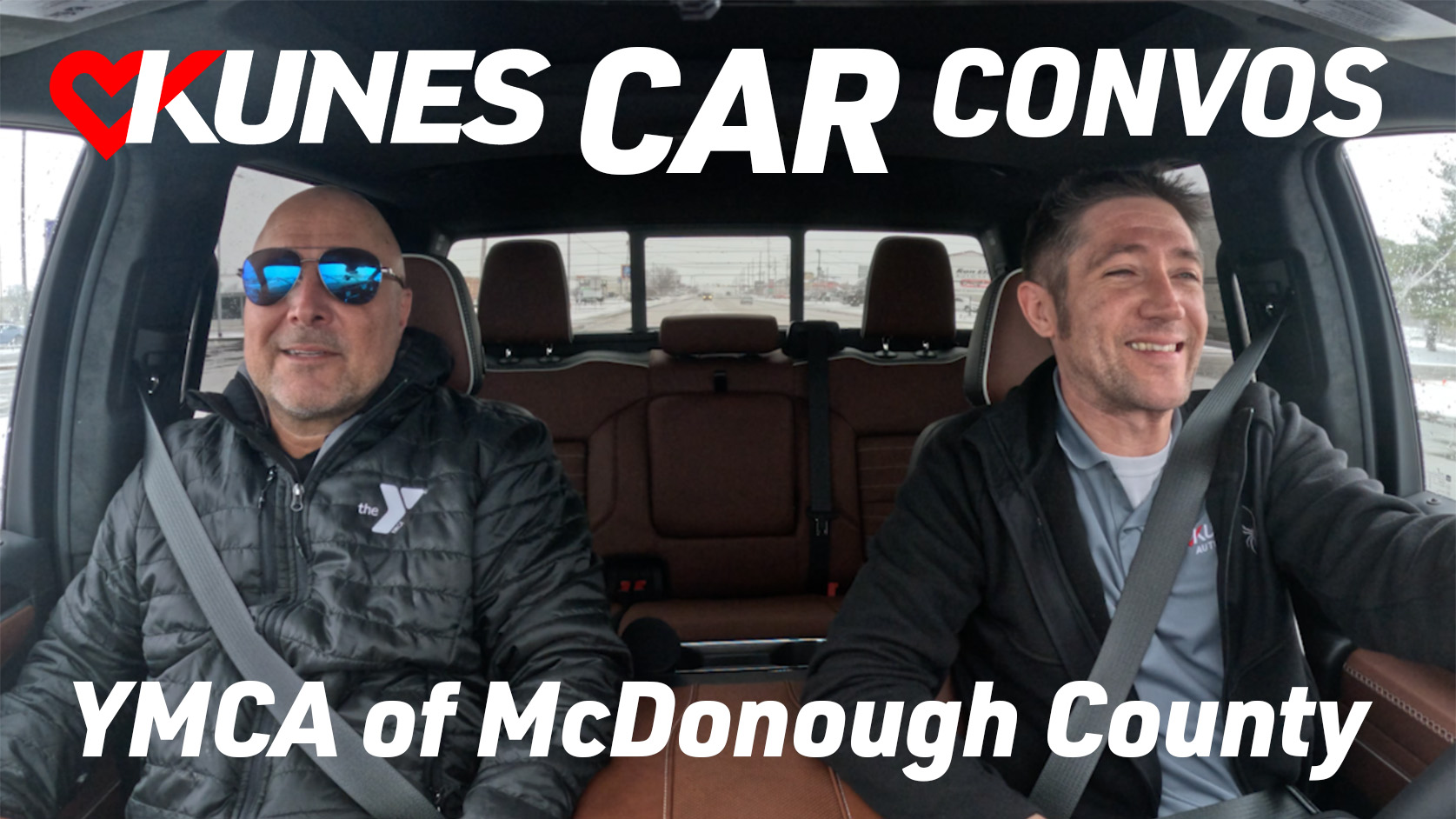 Pictured left to right: YMCA of McDonough County's CEO, Nick Knowles, and Kunes Auto Group of Macomb's Sales Manager, Spencer Swartsbaugh, laughing together in the 2024 GMC Sierra Denali