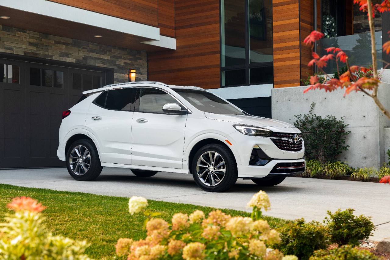 a white buick crossover parked by a house